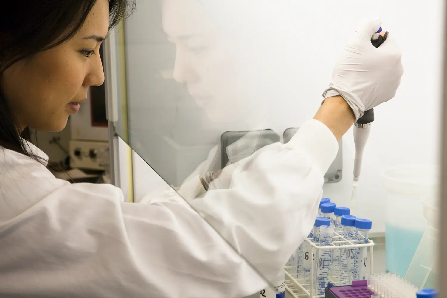 A lab worker conducting a test with a pipette and test tubes